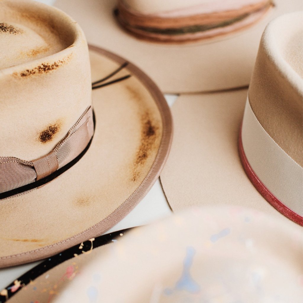 Stack of PHYLLi hats made in creamy beige felt, featuring handcrafted trims and soft neutral tones. A celebration of timeless, wearable design.