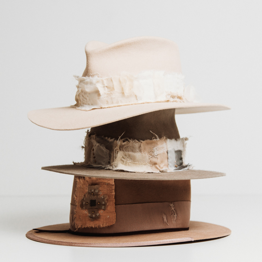 Stack of wabi sabi hats by PHYLLi Designs with raw-edge trims and earthy tones