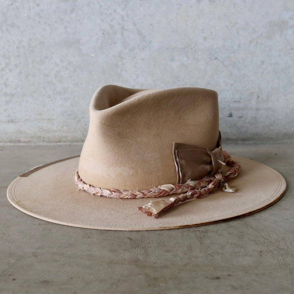 Limited edition felt hat by PHYLLi Designs in distressed Sand, featuring silk plait and bow detail. Handmade 1-of-1 custom hat.