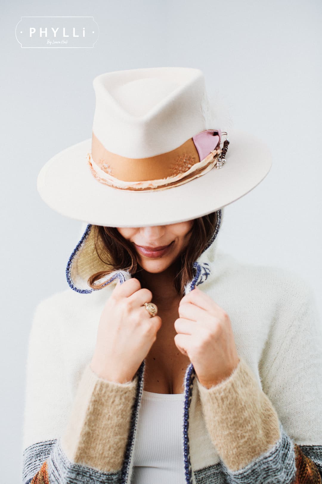 Woman wearing the Malibu beige felt hat by PHYLLi Designs with copper band and marigold sari silk trim.