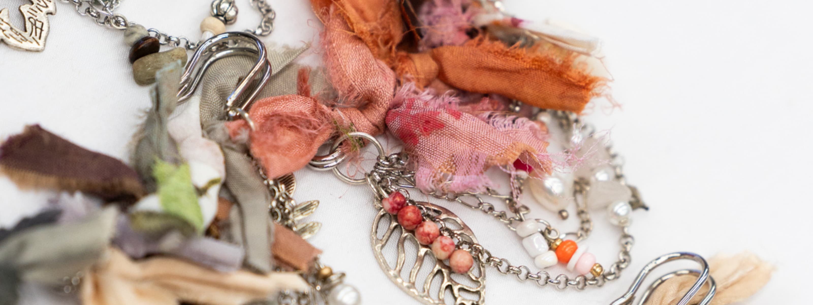 Close-up of a decorative hat pin with various charms on a white background