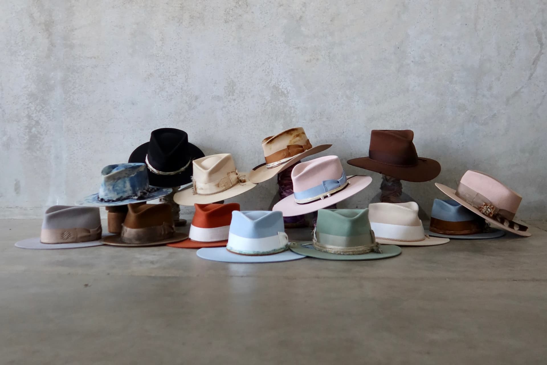 Collection of hats displayed on a flat surface with a neutral background