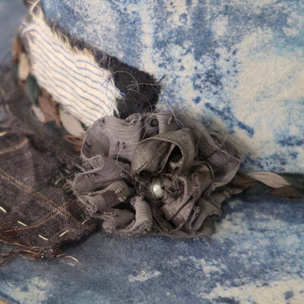 Close up detail of the Aizome Limited Edition felt hat showing sari silk lapel bloom with pearl centre.