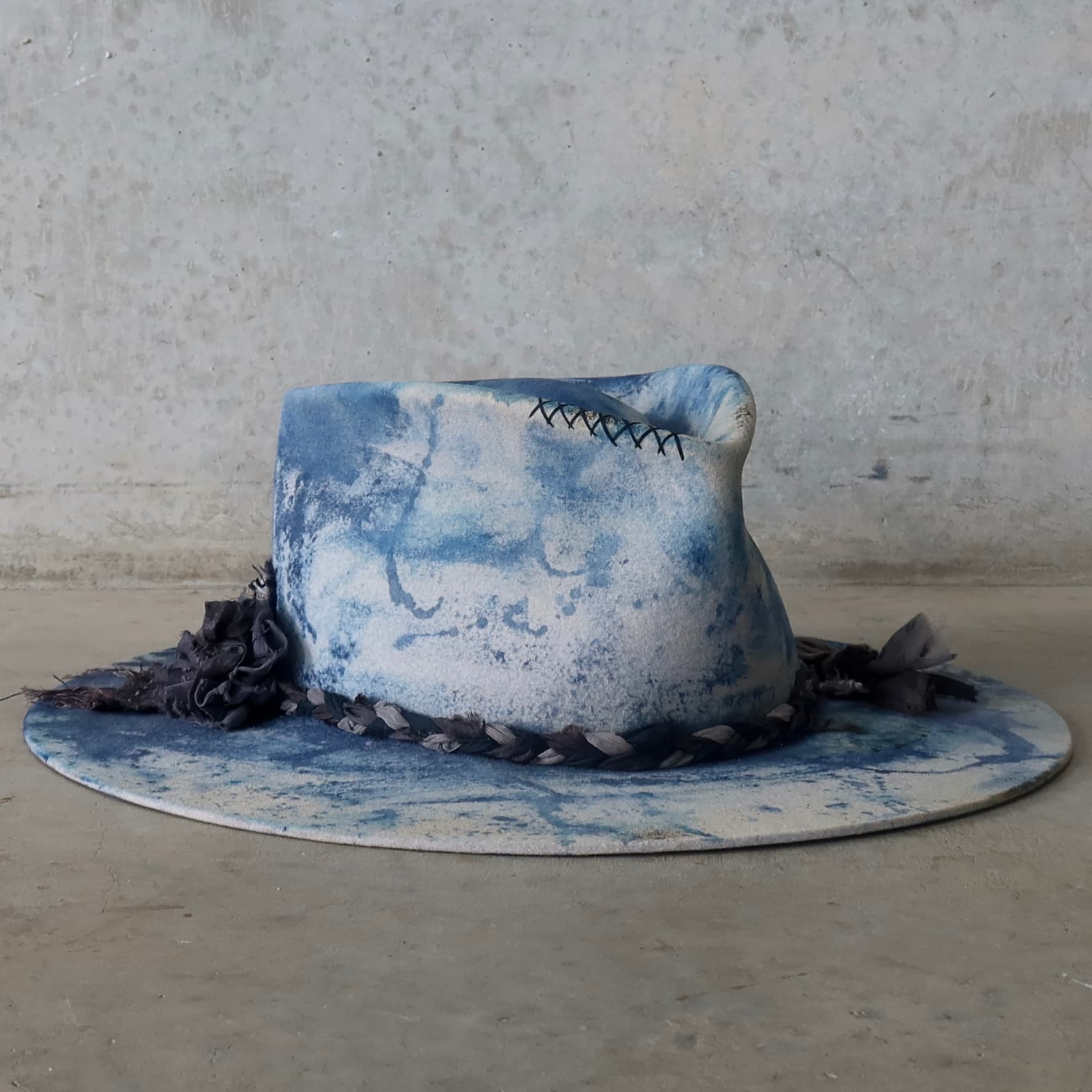 Front right angle of the dove grey indigo tie dye felt hat Aizome Limited Edition by PHYLLi Designs with hand stitched cross detail.