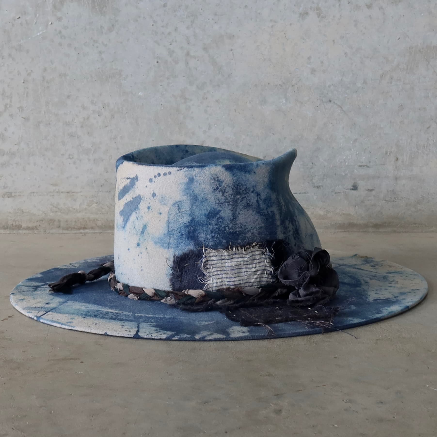 Back right angle of the dove grey indigo tie dye felt hat Aizome Limited Edition by PHYLLi Designs with patchwork and sari silk lapel bloom.