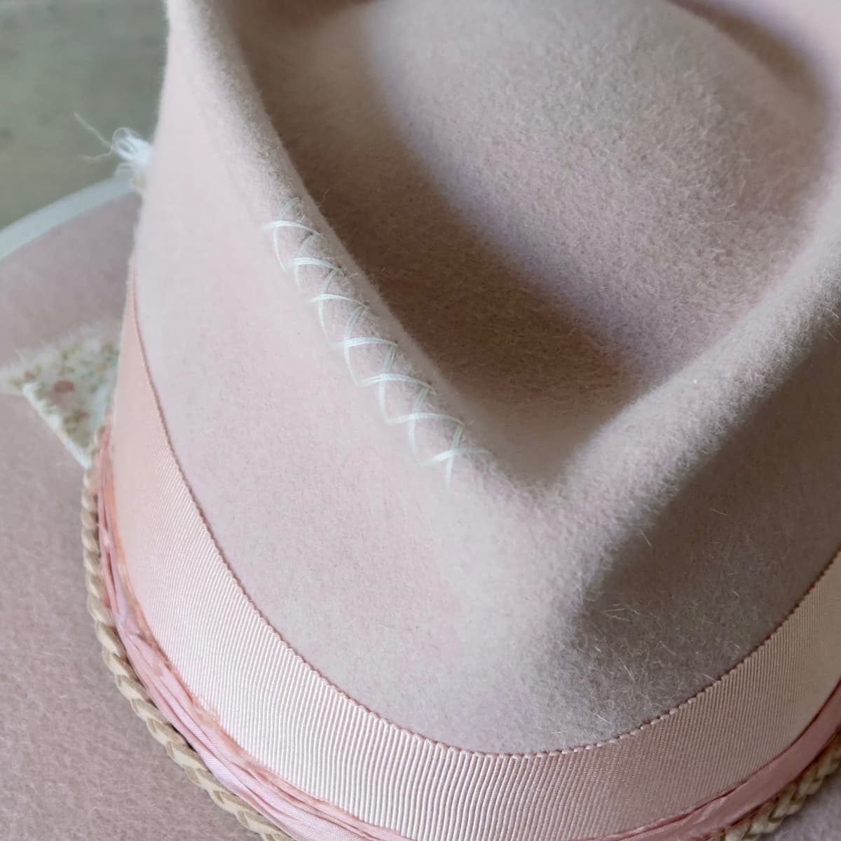 Close up detail of the Argyle Limited Edition felt hat showing ivory hand-stitched crosses on the baby pink western weight rabbit felt crown.