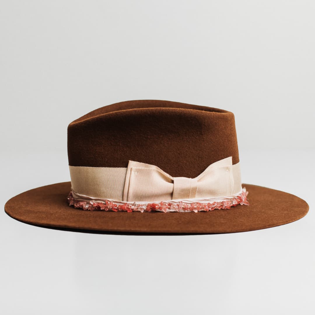 Left side view of the Australis caramel felt hat by PHYLLi Designs with ballerina pink sari silk trim and rose quartz crystal necklace.
