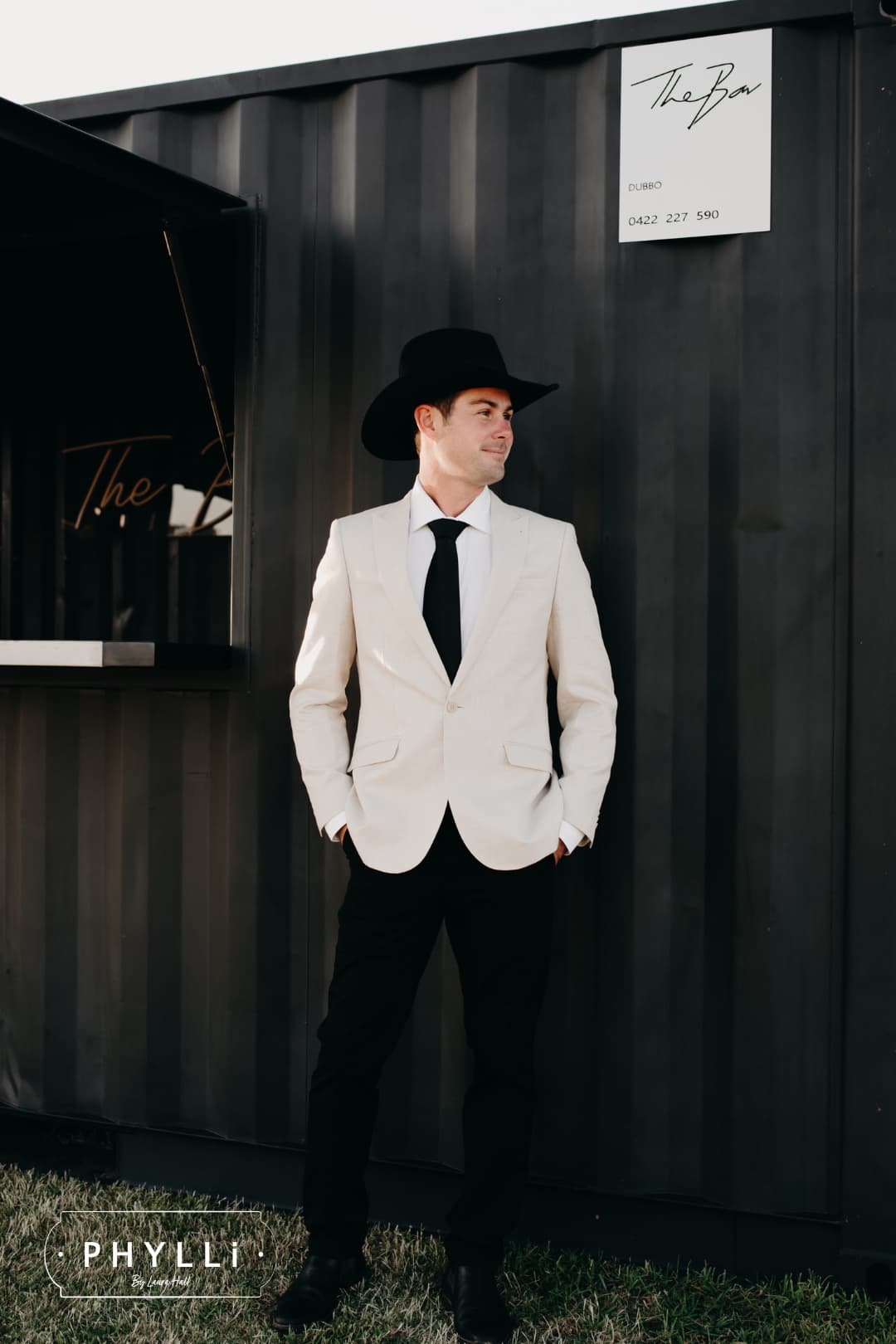 Male model wearing the black felt cowboy hat B&W Wheeler by PHYLLi Designs with black Japanese grosgrain band outside The Bar in Dubbo.