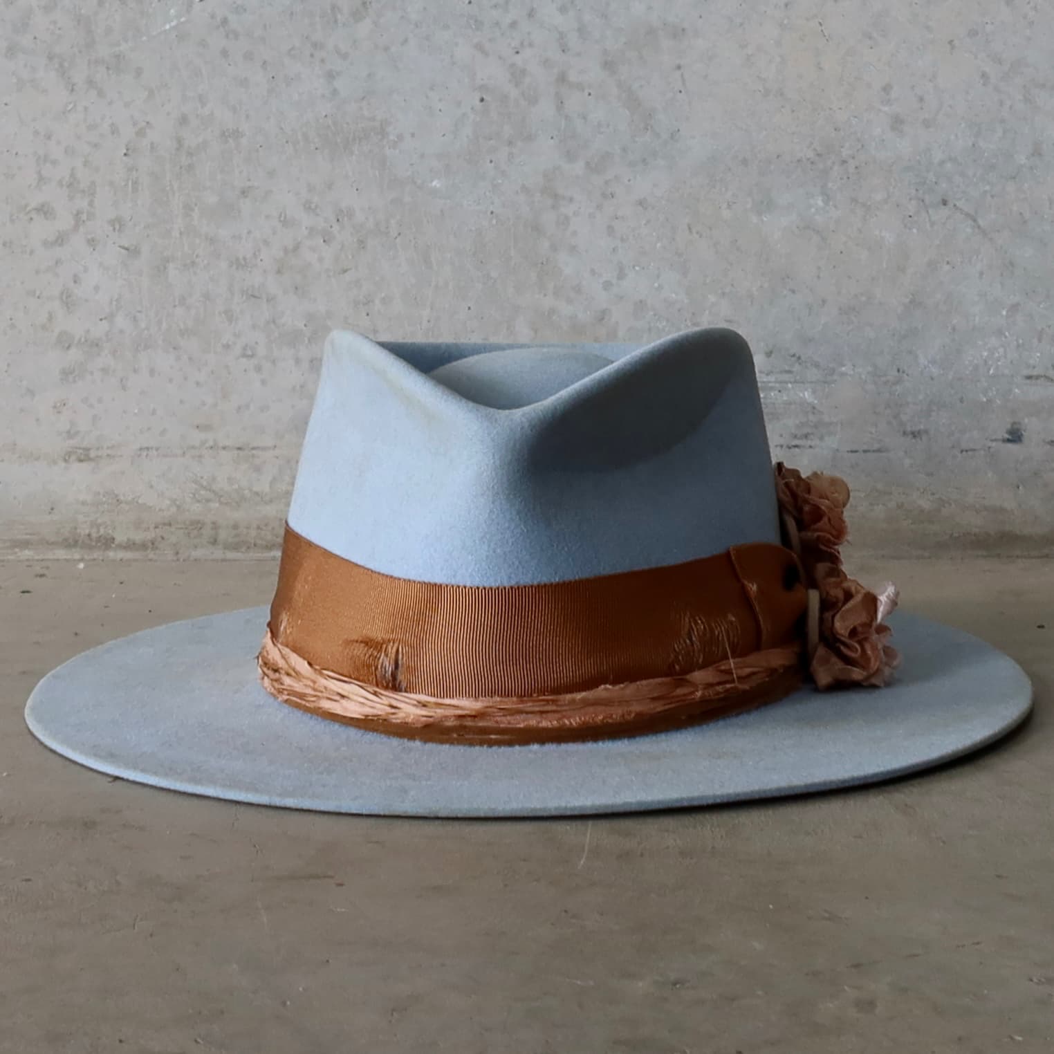 Crystal blue felt hat Blue Bloom by PHYLLi Designs with distressed copper Japanese grosgrain bow band and Dirty Rose sari silk Lapel Blooms.