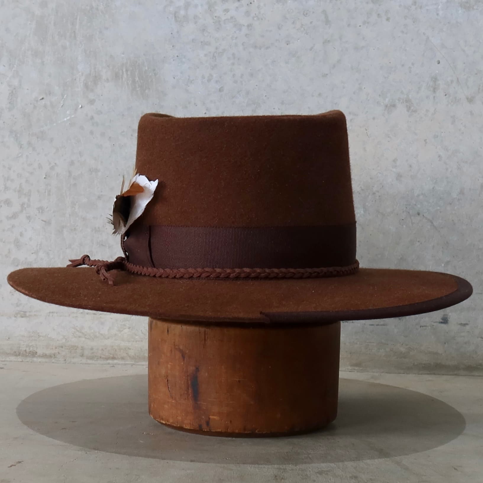 Back view of the chocolate felt hat Botero by PHYLLi Designs featuring plaited chocolate suede string and dark brown grosgrain band.