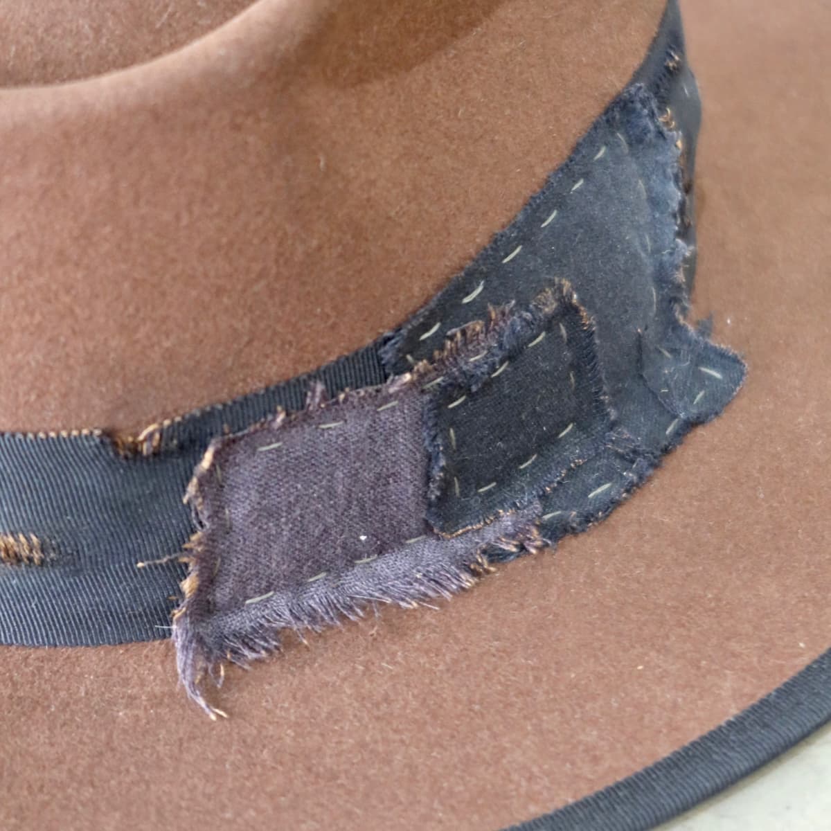 Close up detail of the Brenner Limited Edition felt hat showing raw edge patchwork and hand stitching.