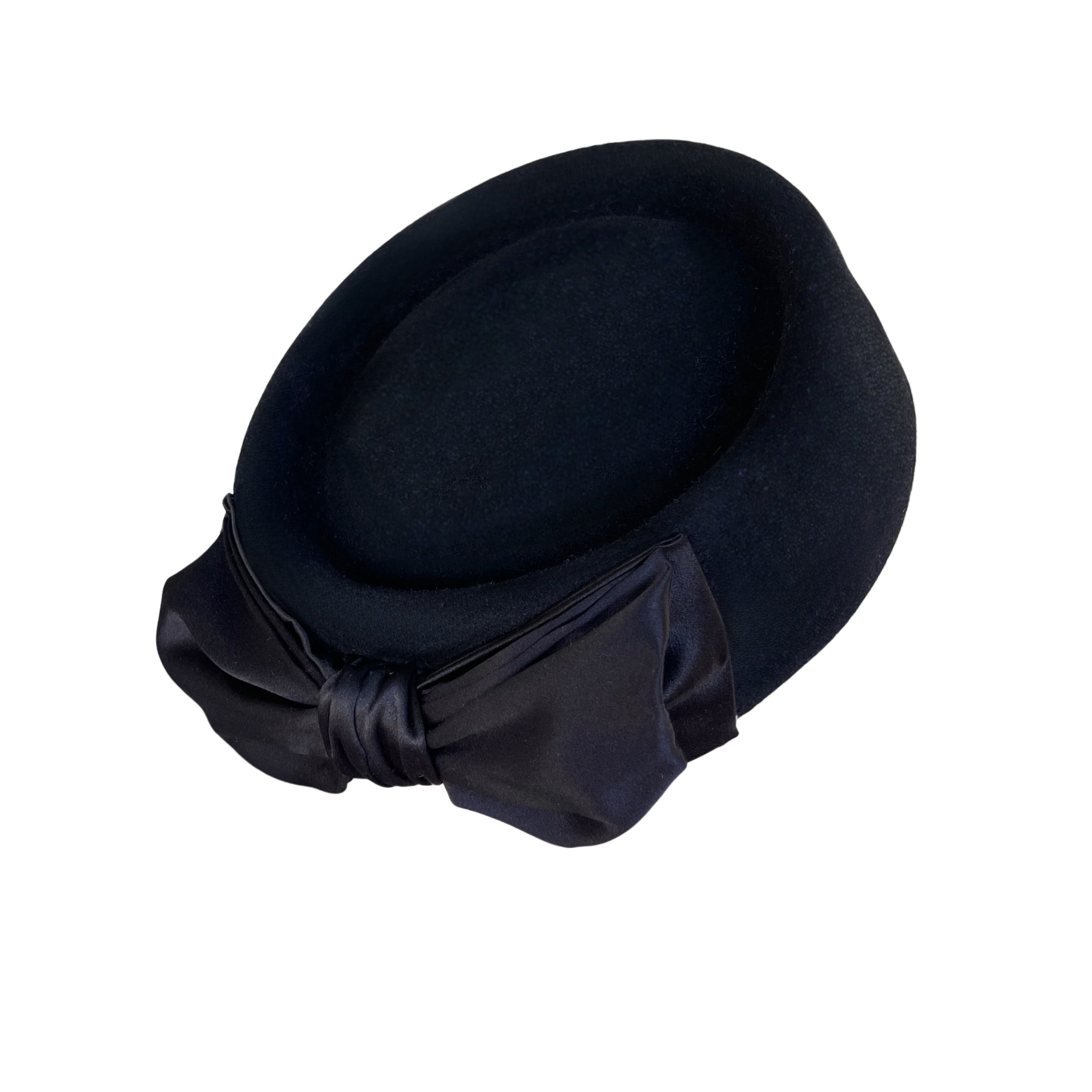 Back right angle of the black felt pillbox hat Brooke Pillbox by PHYLLi Designs with Italian silk double bow trim.