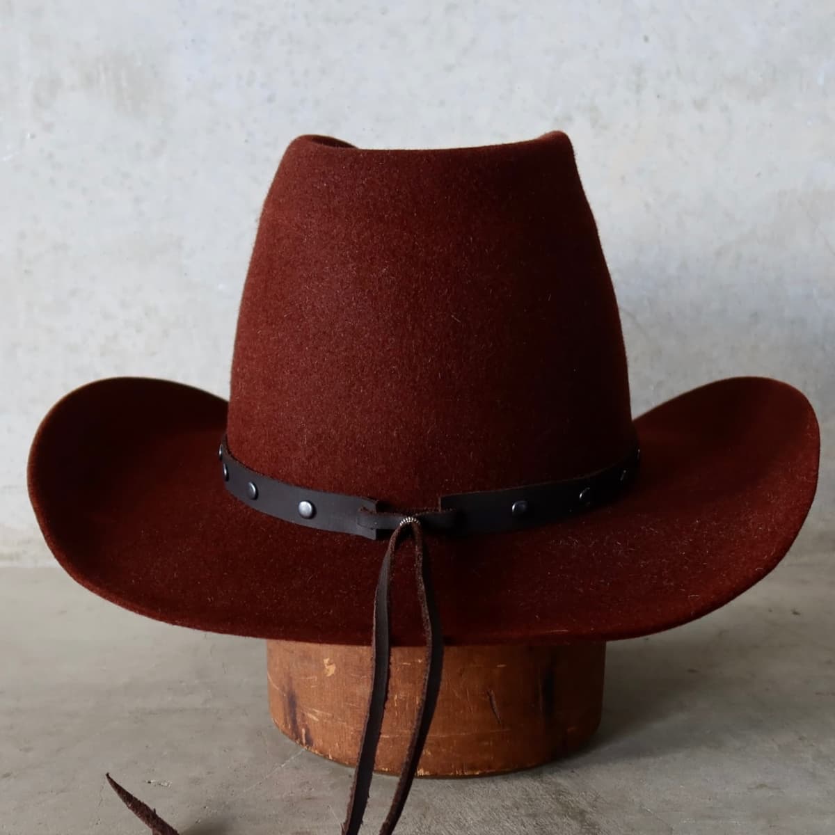 Back view of the Russet felt cowboy hat Burgundy by PHYLLi Designs featuring dark brown leather tie back hat band.