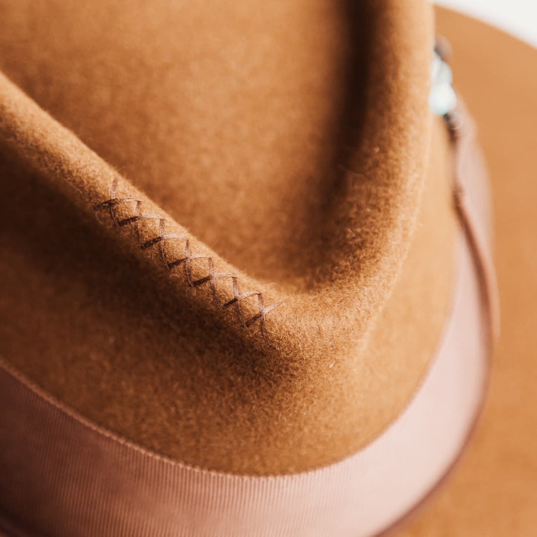Close up detail of the Calaveras felt hat showing hand-stitched cross detail in chocolate thread on the crown.