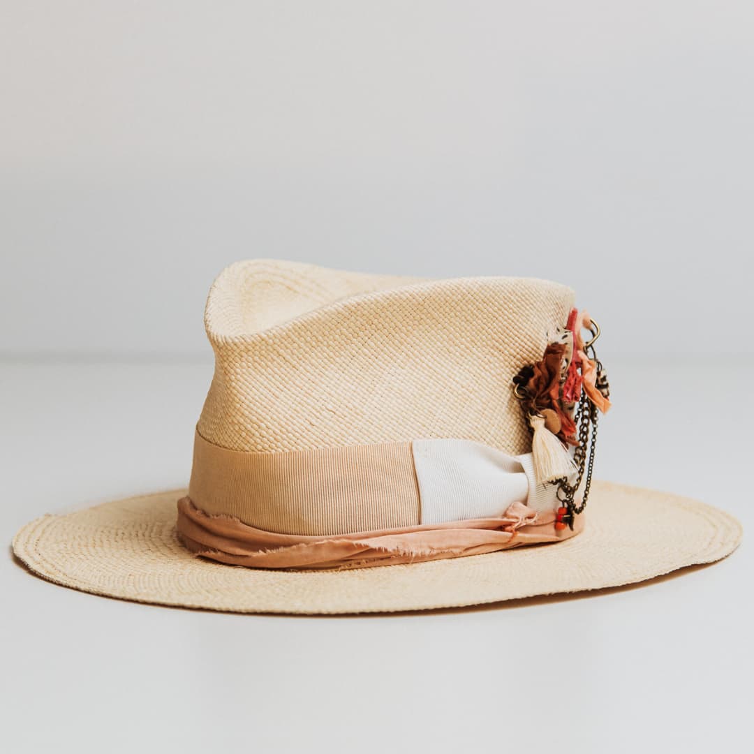Calipso Panama hat in Natural toquilla straw with Sand grosgrain band and bronze chunky hat pin with Ivory tassel.