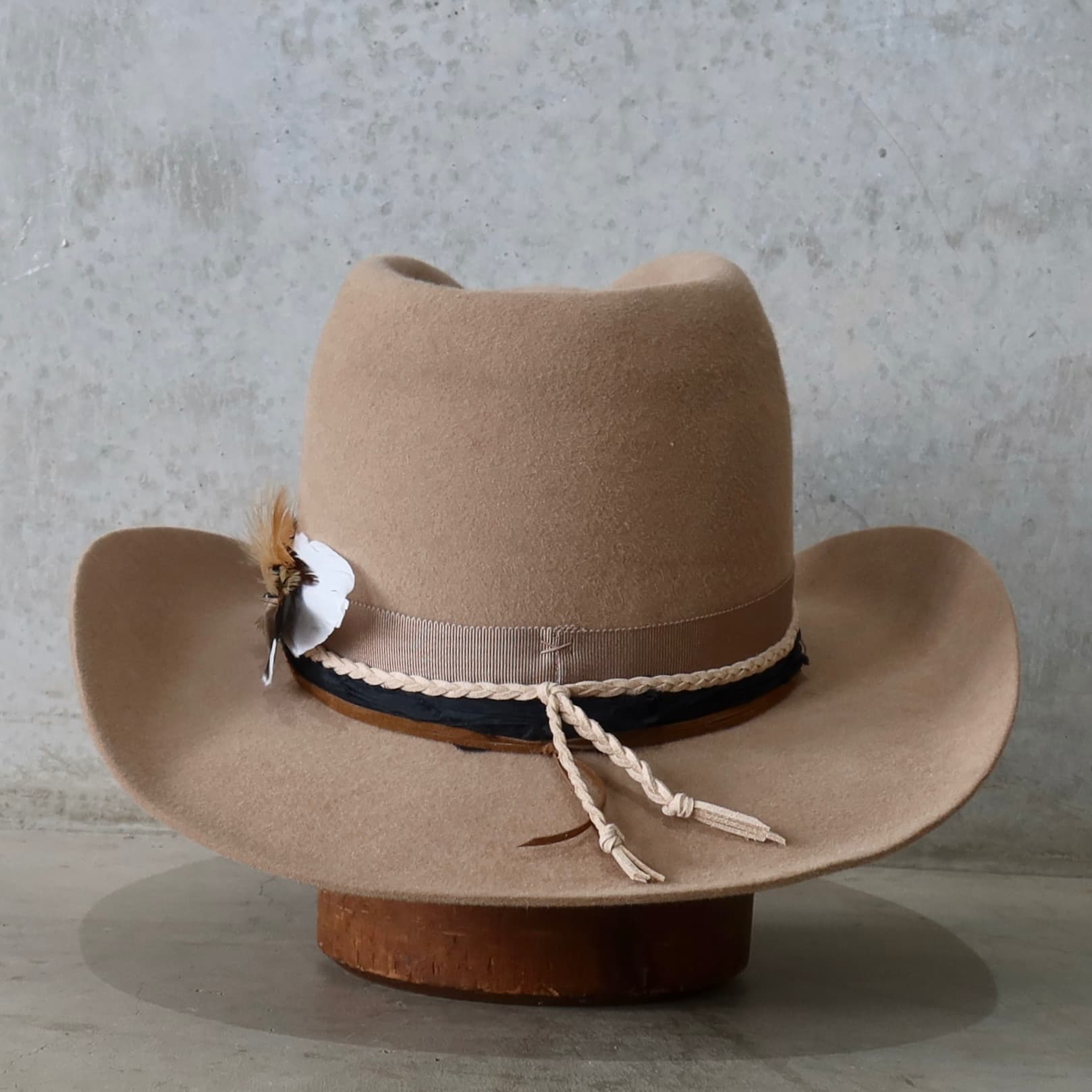 Back view of the camel felt cowboy hat Casey by PHYLLi Designs featuring braided suede strings and layered sari silk trimming.