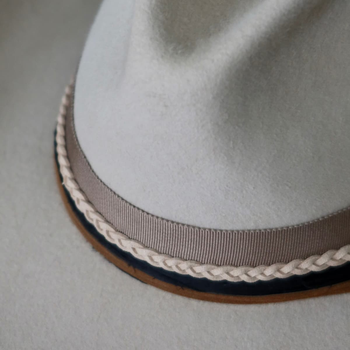 Close up detail of the Casey Beige cowboy hat showing taupe Japanese grosgrain band with nude plaited suede wrap.