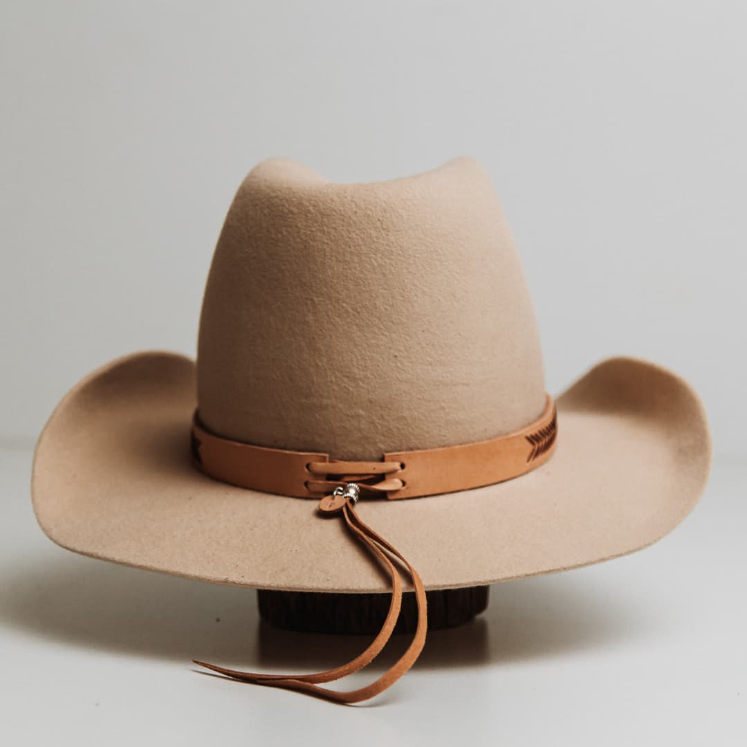 Back view of the Chevron Hat Band featuring adjustable kangaroo hide tieback with brushed silver tieback fasteners on a beige felt cowboy hat by PHYLLi Designs.
