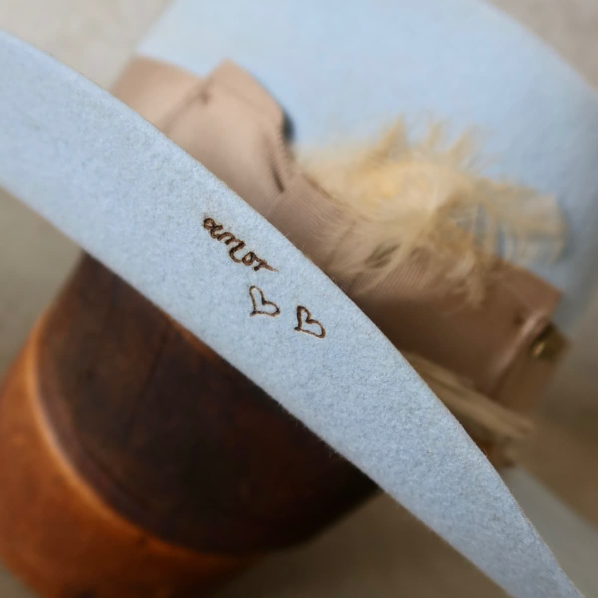 Close up detail of the Clareville Limited Edition felt cowboy hat showing burnt personalised branding on the crystal blue felt brim.