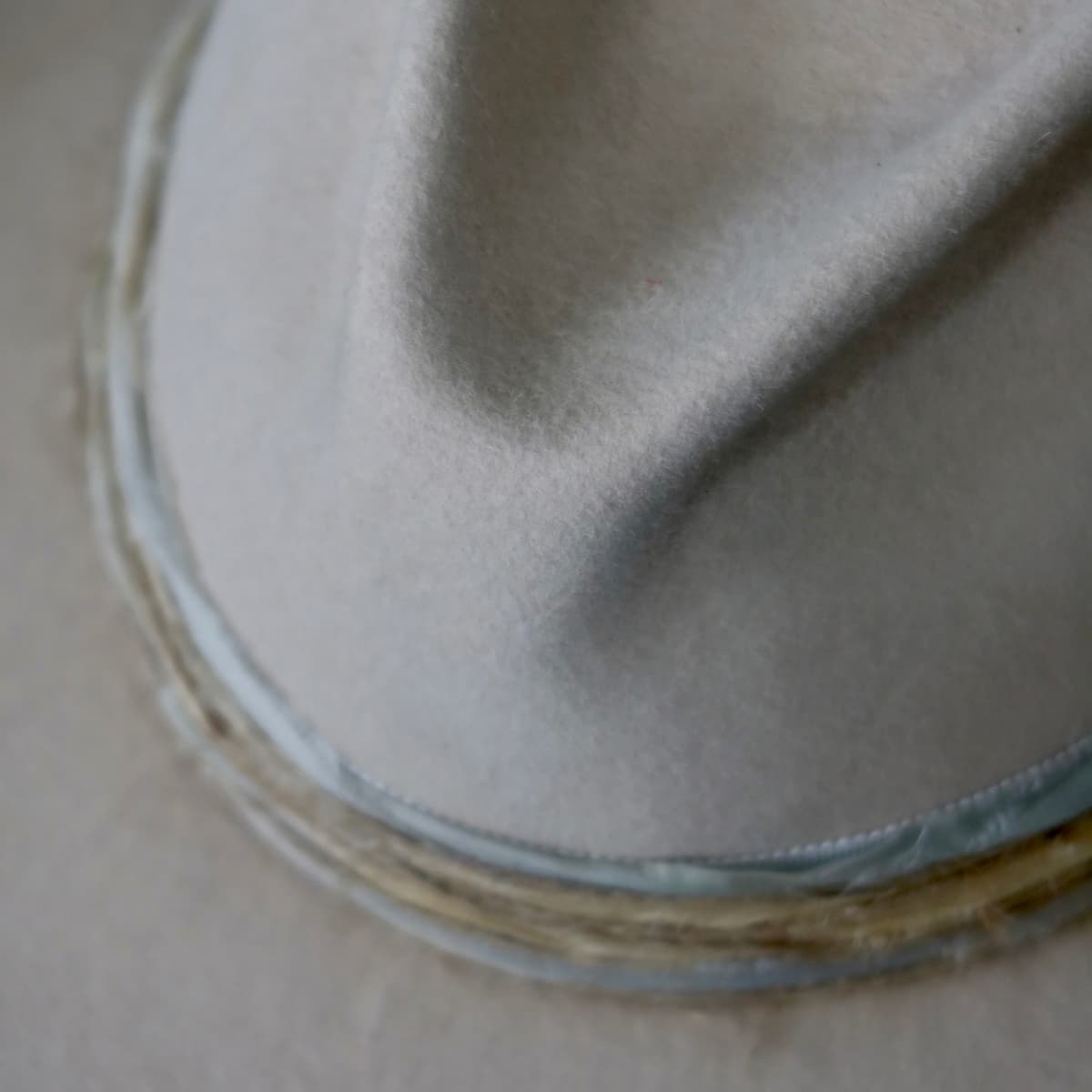 Close up detail of the Coastline Cowgirl beige felt cowboy hat showing ivory Japanese grosgrain band and layered twine wraps.