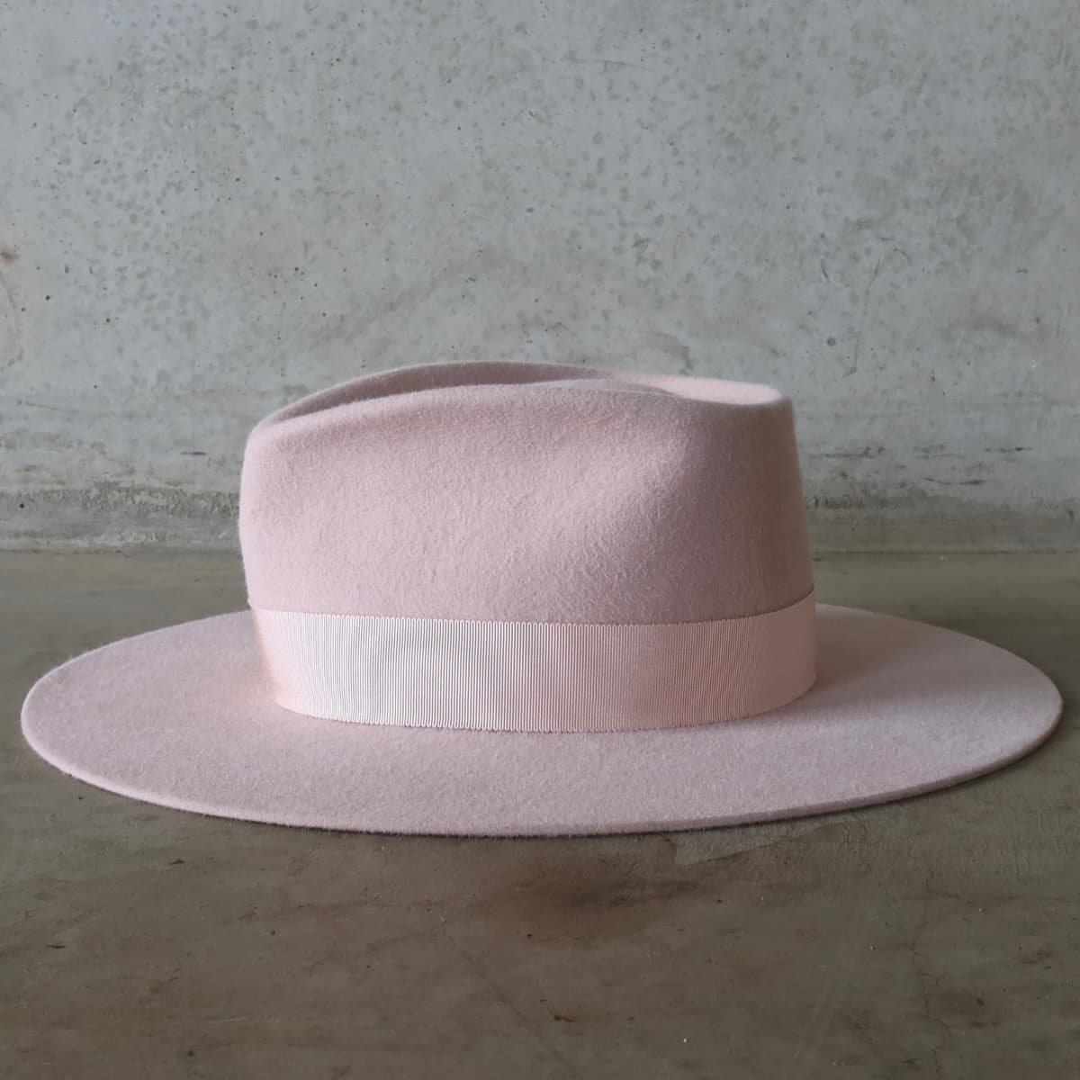 Left side view of the baby pink hat Core Baby Pink by PHYLLi Designs with salmon Japanese grosgrain band.