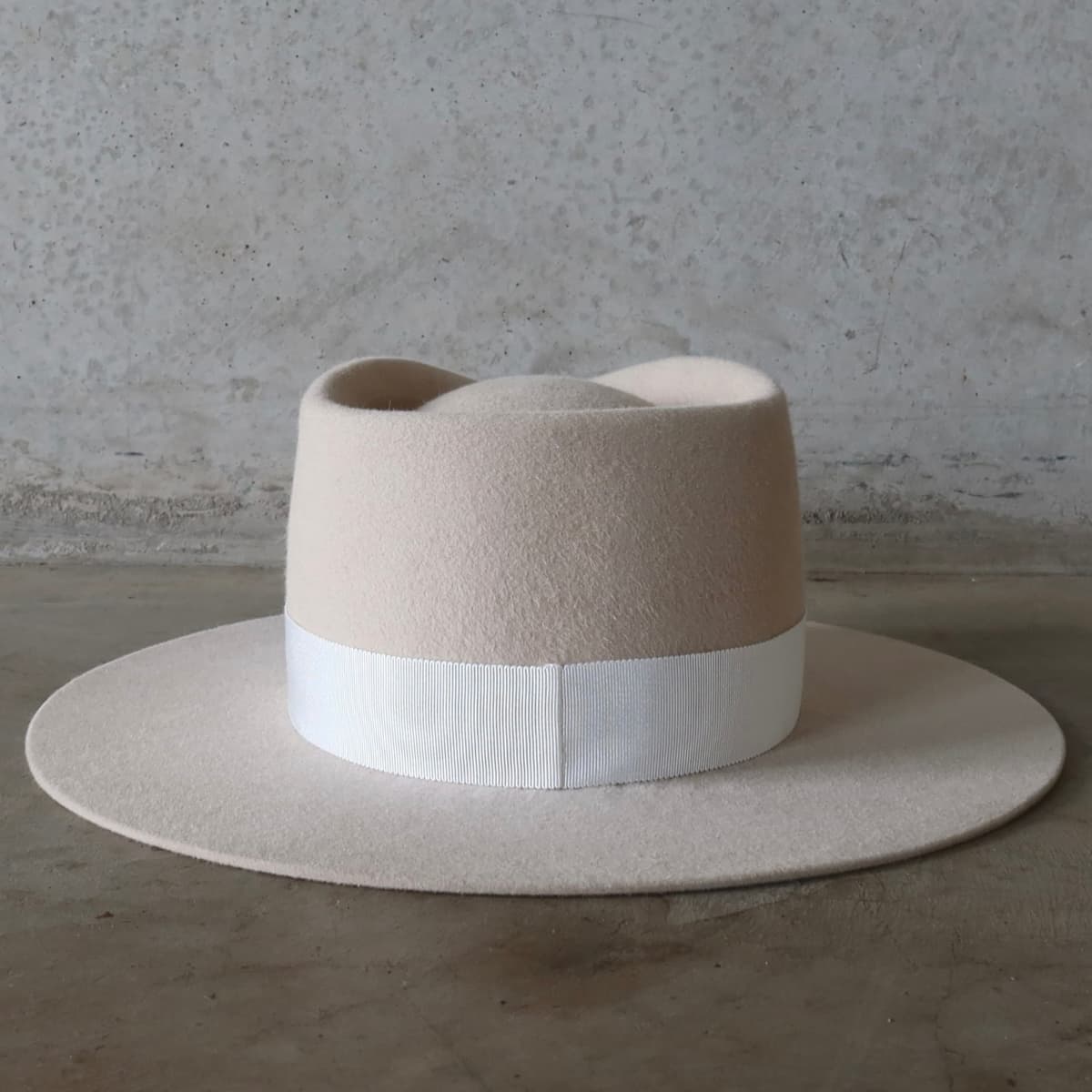 Back view of the beige felt hat Core Beige by PHYLLi Designs featuring interchangeable ivory Japanese grosgrain band.