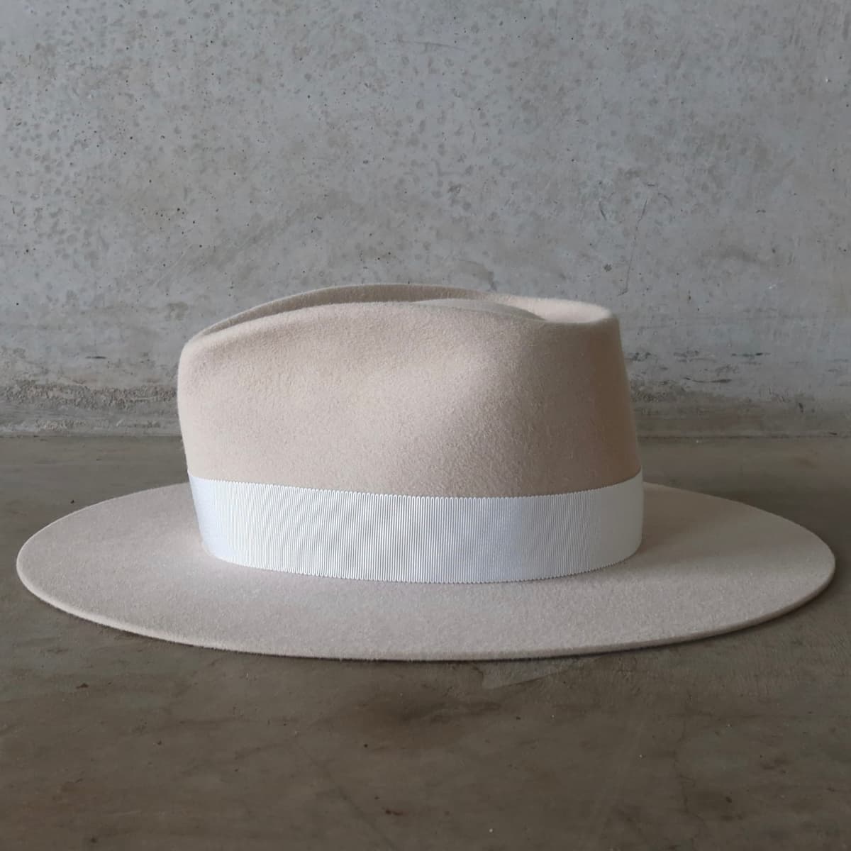 Left side view of the beige felt hat Core Beige by PHYLLi Designs with ivory Japanese grosgrain band.