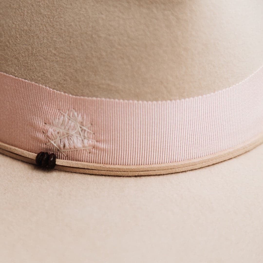 Close up detail of the Curlewis felt hat showing distressed sherbet pink grosgrain band with ivory darned patch stitching.