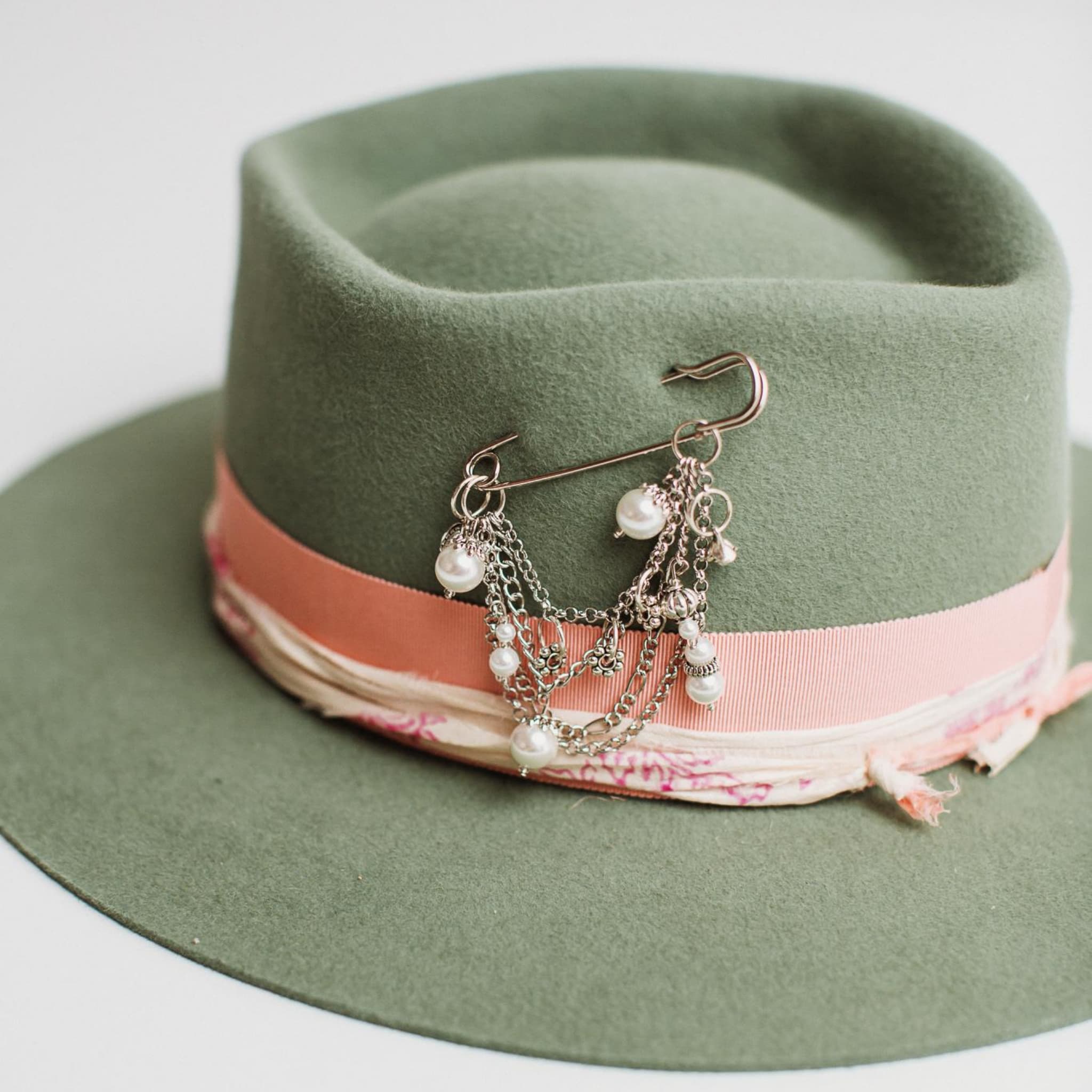 Close up of pearl beaded silver chunky hat pin and sari silk trim on the Diamonds & Pearls eucalyptus felt hat by PHYLLi Designs.