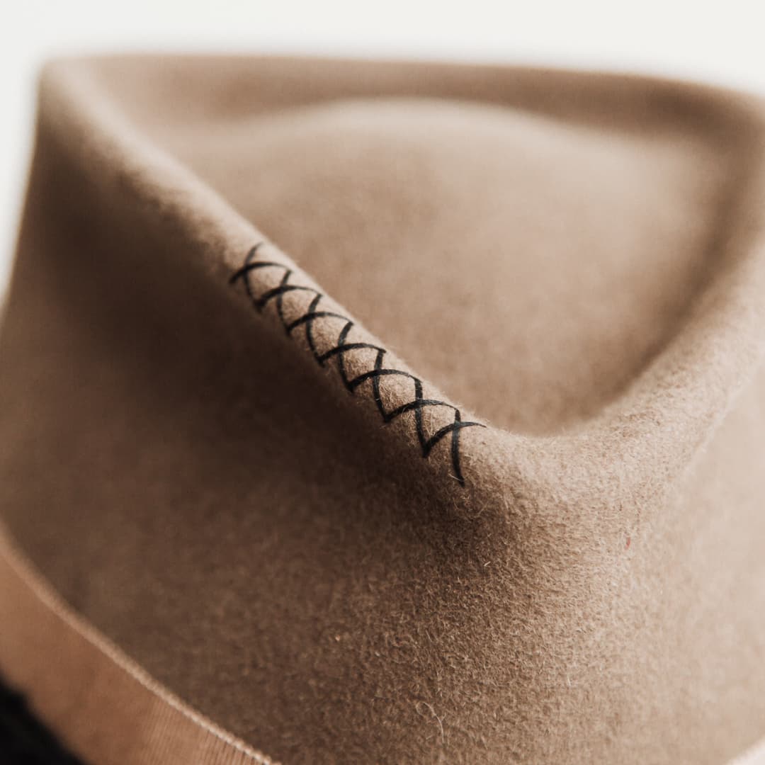 Close up detail of the Dirty Jane felt hat showing hand stitched black crosses on the crown.