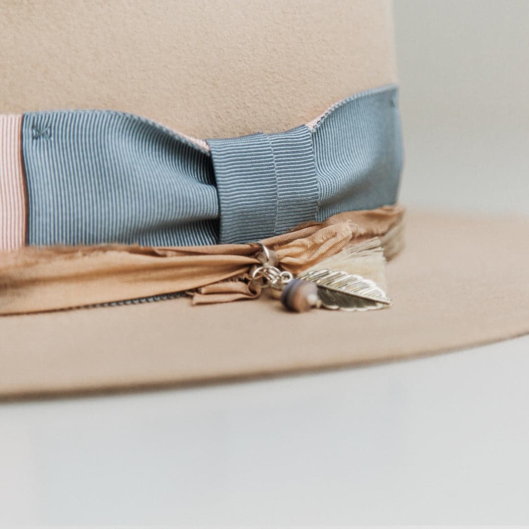 Close up detail of the Eleanor felt hat showing distressed grosgrain band with ivory hand-stitched crosses.