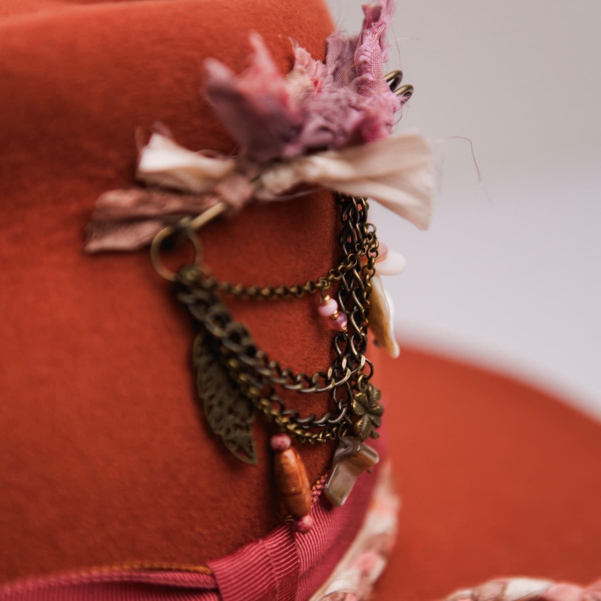 Close up detail of the Evans felt cowboy hat showing bronze chunky hat pin with tassel, charms and sari silk ties.
