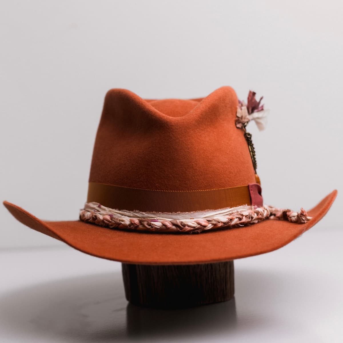 Front view of the Spiced Pumpkin felt cowboy hat Evans by PHYLLi Designs with rust Japanese grosgrain band and watermelon bow.