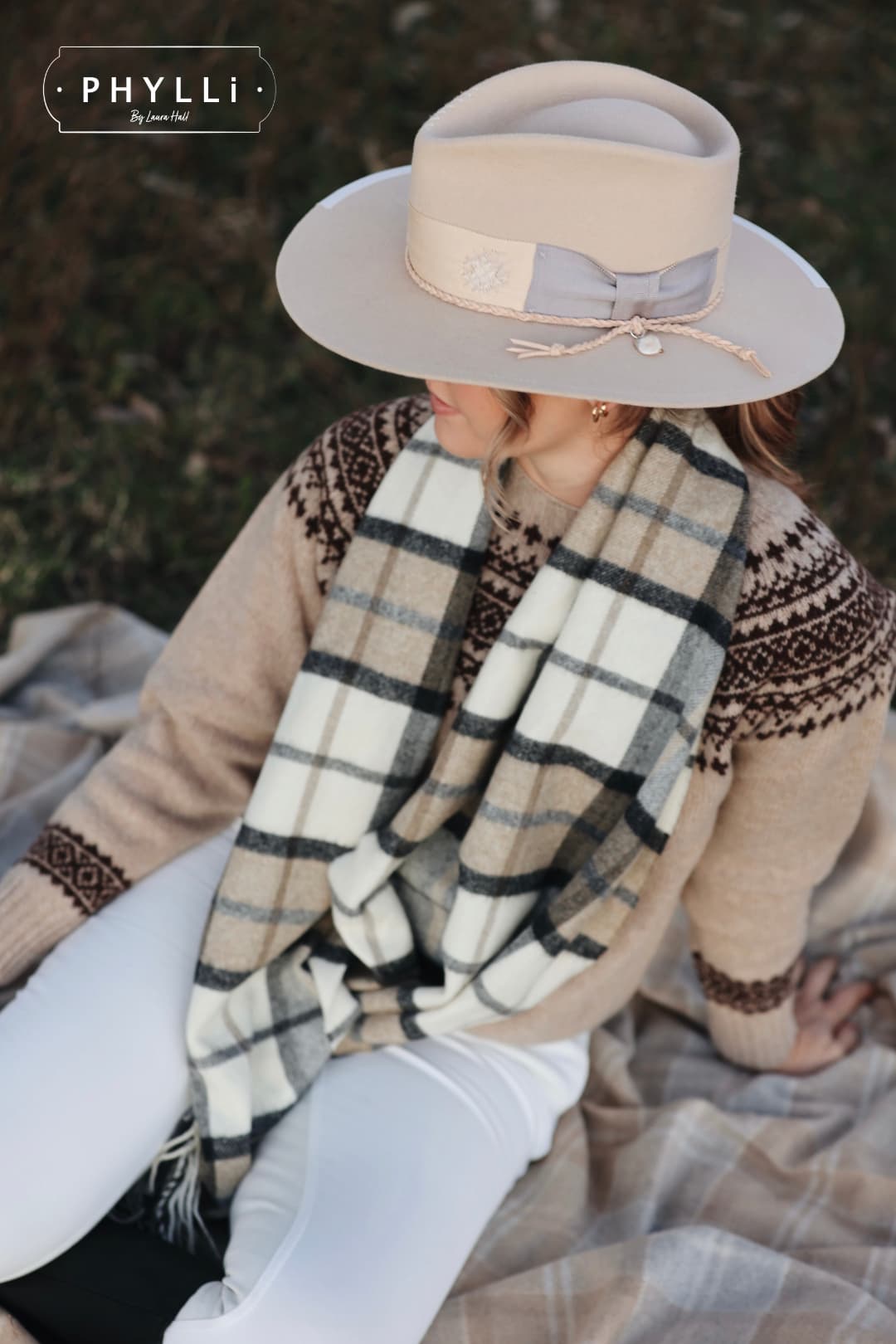Woman wearing Fallon beige felt hat by PHYLLi Designs during countryside photoshoot with knitwear and scarf styling.