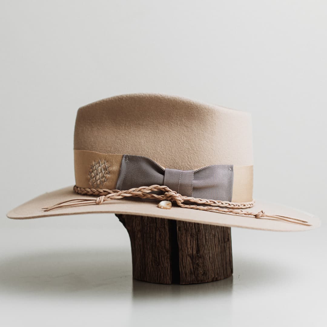 Left side view of Fallon beige felt hat by PHYLLi Designs with Japanese grosgrain brim trim and plaited suede string detail.