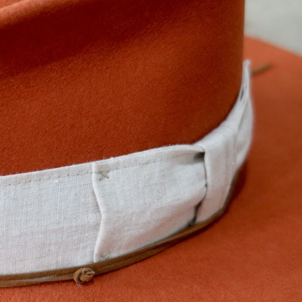 Close up detail of the Flax felt hat showing natural linen bow band with hand stitching.