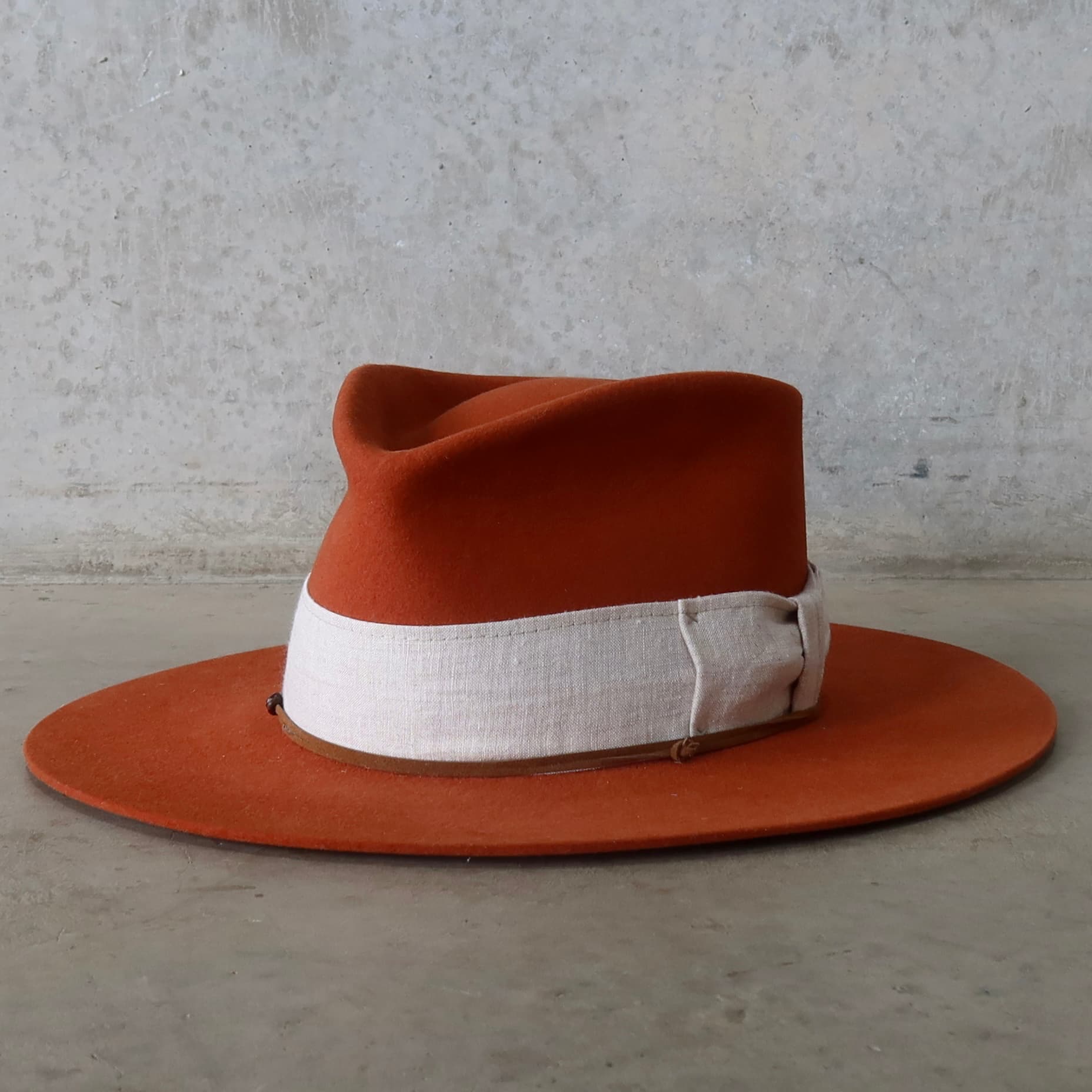Front left angle of the Spiced Pumpkin felt hat Flax by PHYLLi Designs with linen bow band and suede wrap.