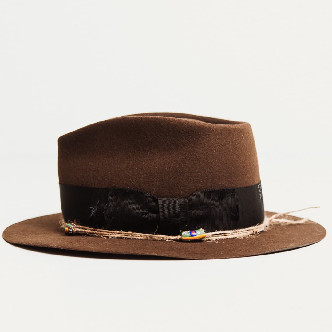 Left side view of the Ghana chocolate felt hat by PHYLLi Designs with twine wraps and recycled glass beads.