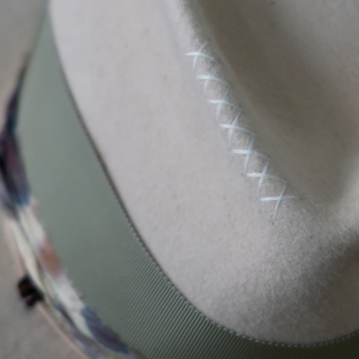 Close up detail of the Grasslands felt hat showing hand-stitched ivory crosses on the crown.