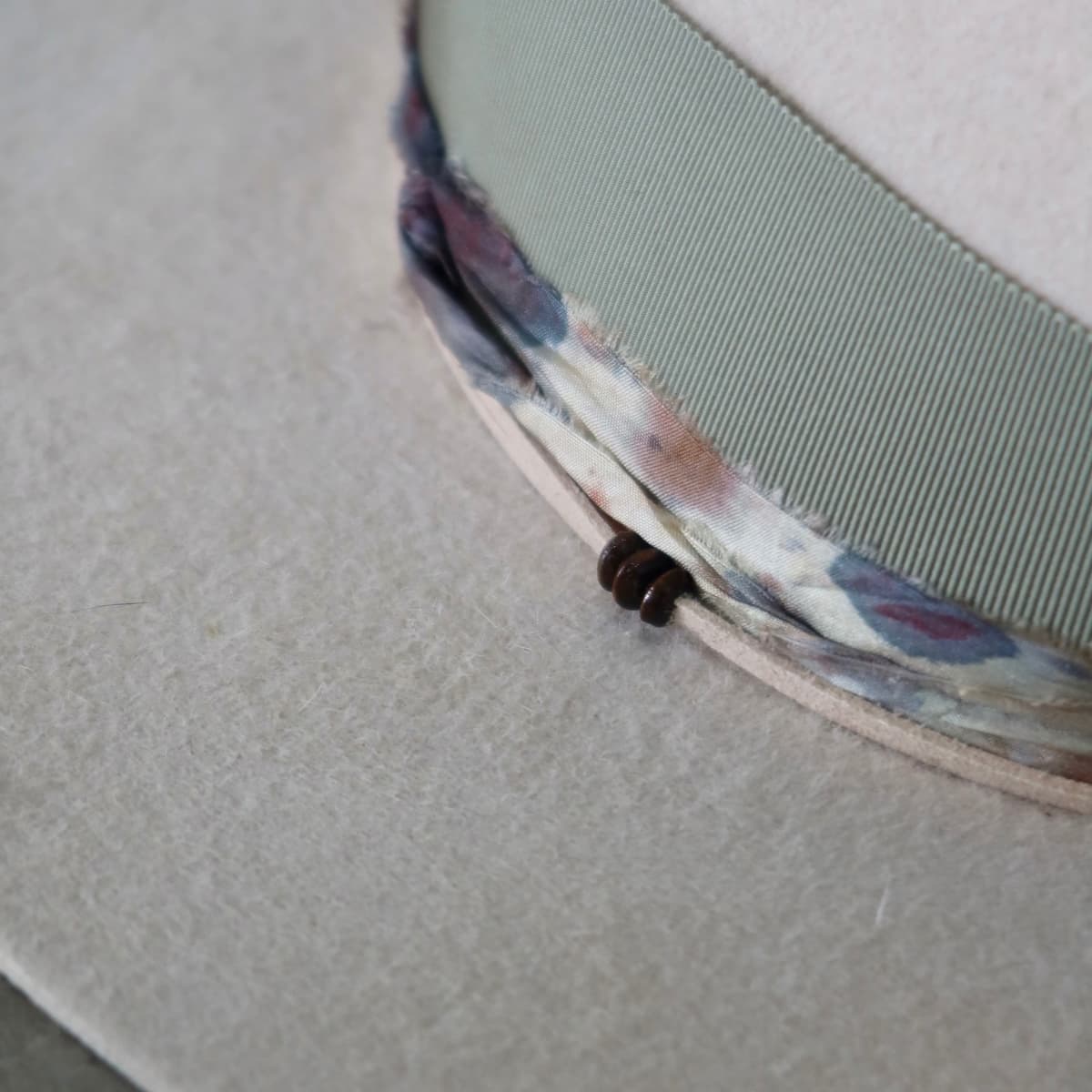 Close up detail of the Grasslands felt hat showing sari silk trimming with wooden bead detail.