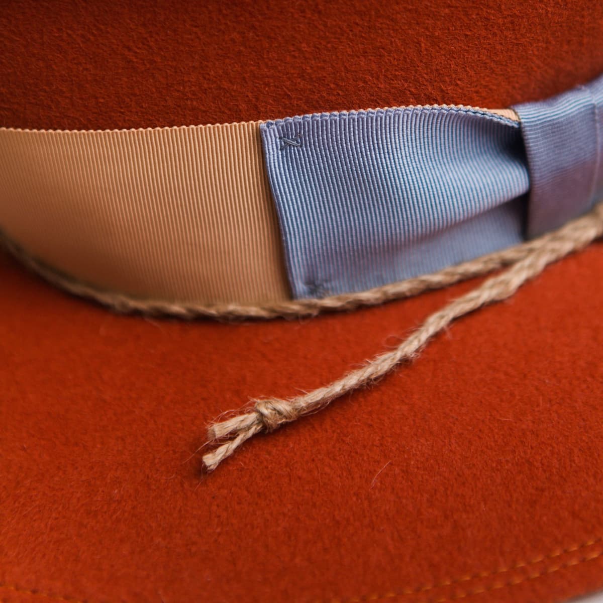 Close up detail of the Howlit felt hat showing apricot Japanese grosgrain band and cornflower bow.