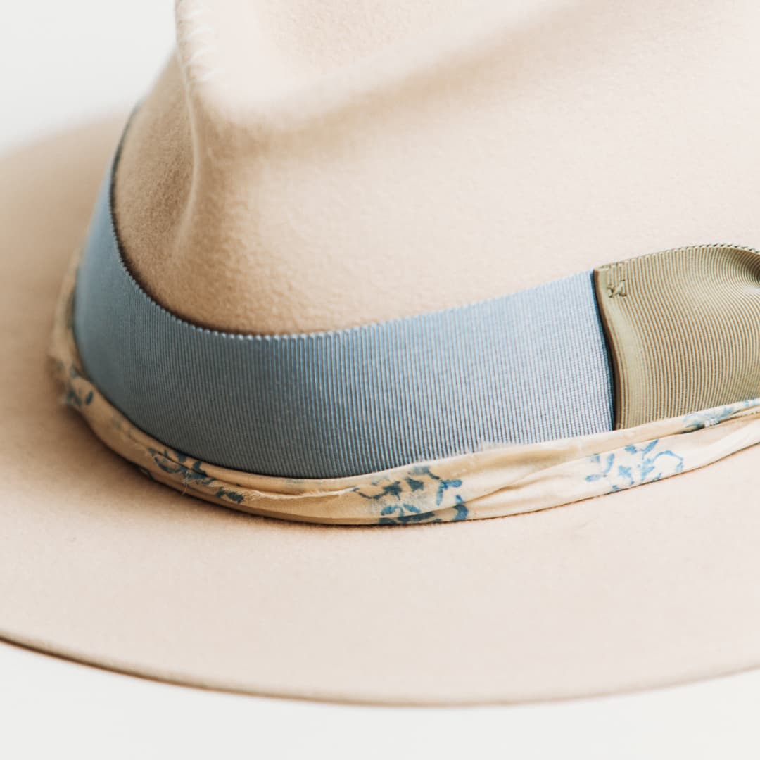 Close up detail of the Hunter felt hat showing cornflower japanese grosgrain band, oil green bow and cream and blue sari silk trim.