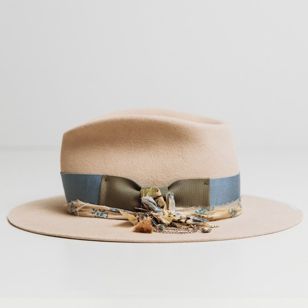 Left side view of the Hunter beige felt hat by PHYLLi Designs with cornflower grosgrain band and ivory brim trim.