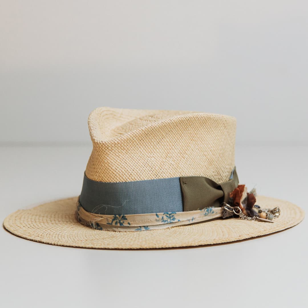 Hunter Panama hat showing Cornflower grosgrain band, Oil Green bow and bronze chunky hat pin.