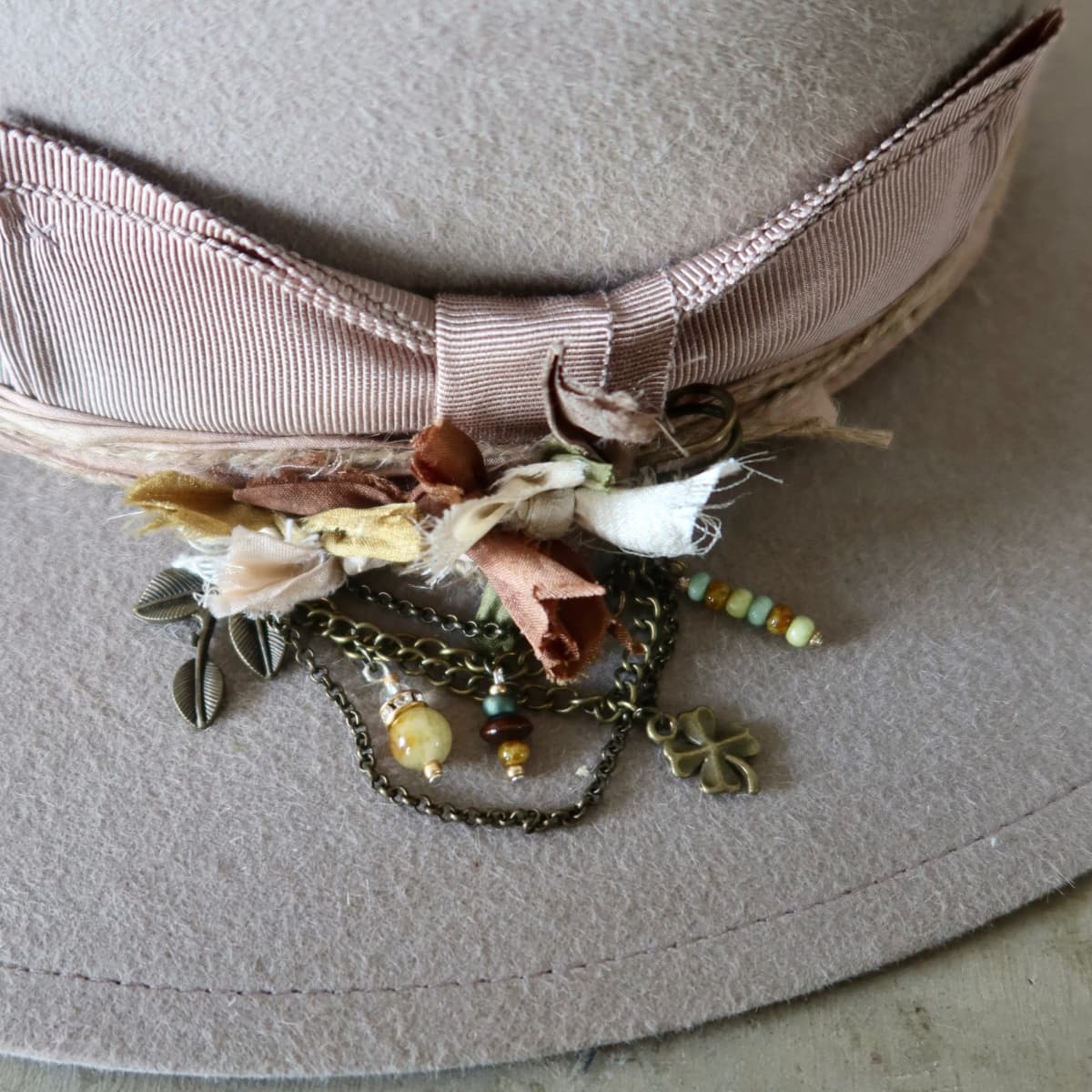 Close up detail of the Huskisson felt hat showing dusty pink sari silk trimming and twine wraps around the crown.