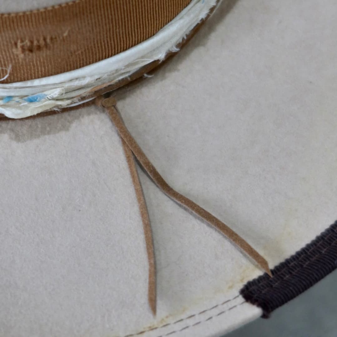 Close up detail of the Iluka cowboy hat showing the distressed copper grosgrain band and chocolate brim trim.