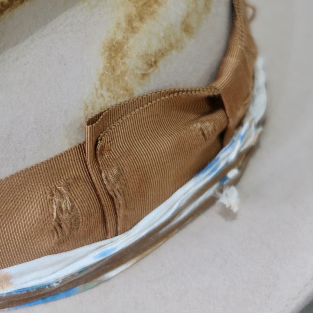 Close up detail of the Iluka cowboy hat showing the distressed copper Japanese grosgrain double bow band.