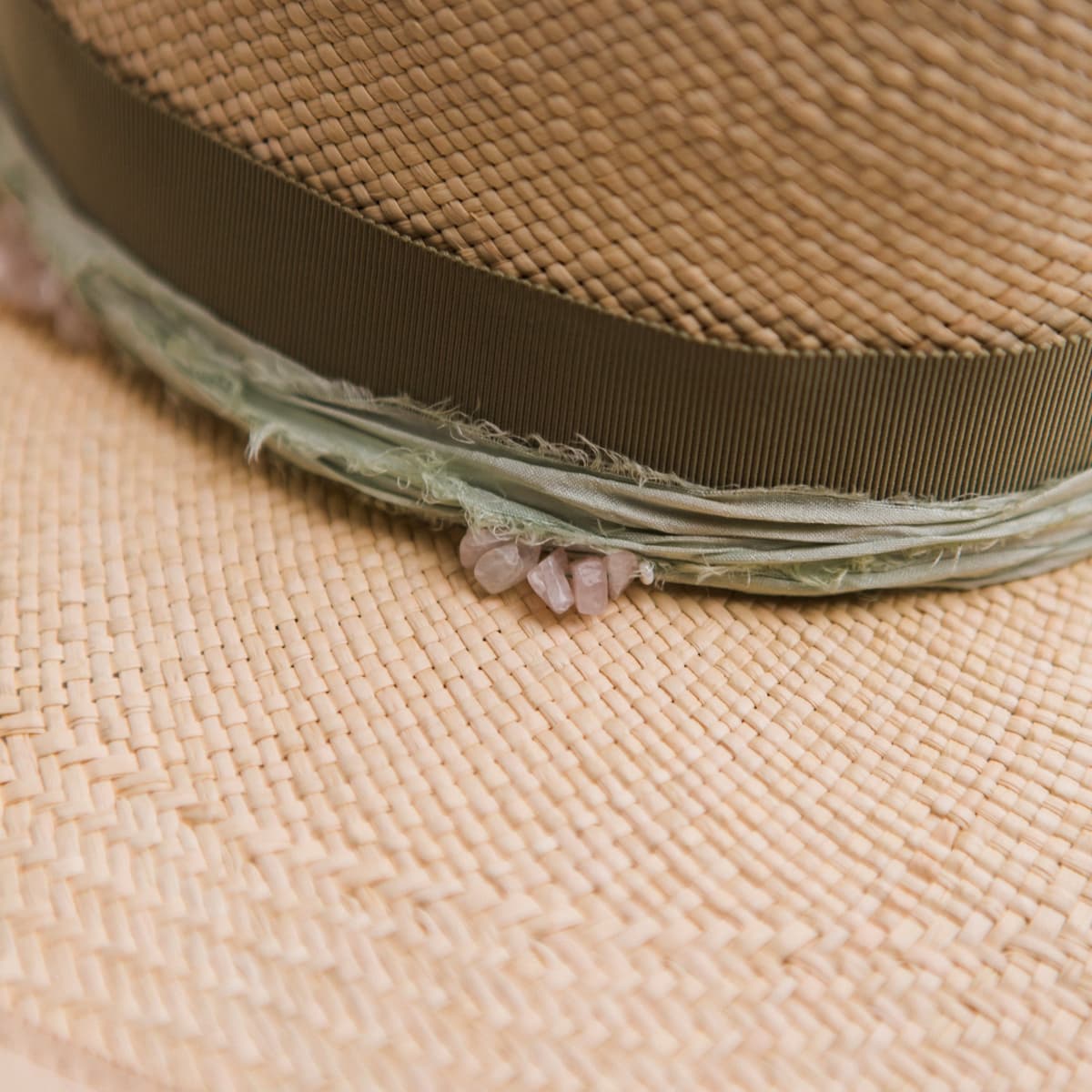 Close up detail of the Isle of Skye 2.0 Panama hat showing mint sari silk trim with rose quartz crystal clusters.