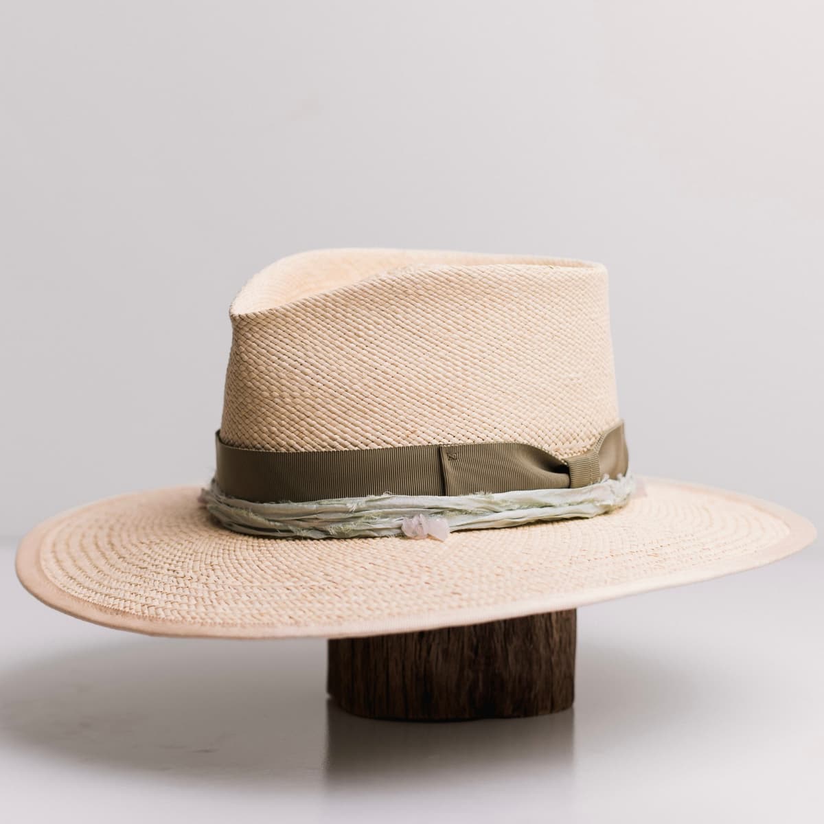 Front left angle of the Isle of Skye 2.0 Natural Panama hat by PHYLLi Designs with oil green Japanese grosgrain bow band and mint sari silk trim.