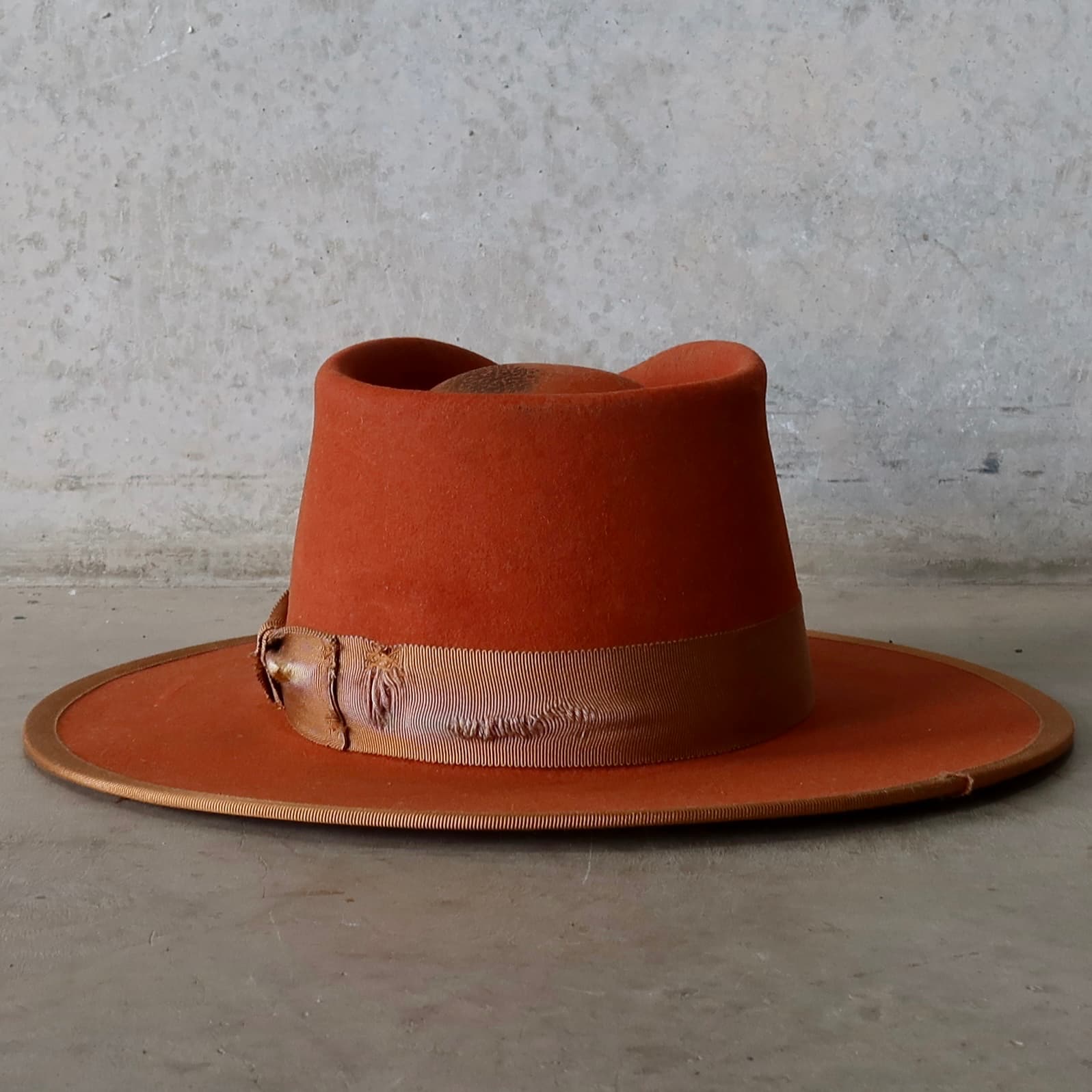 Back view of the Karratha Spiced Pumpkin distressed felt hat by PHYLLi Designs featuring distressed copper grosgrain bow band.